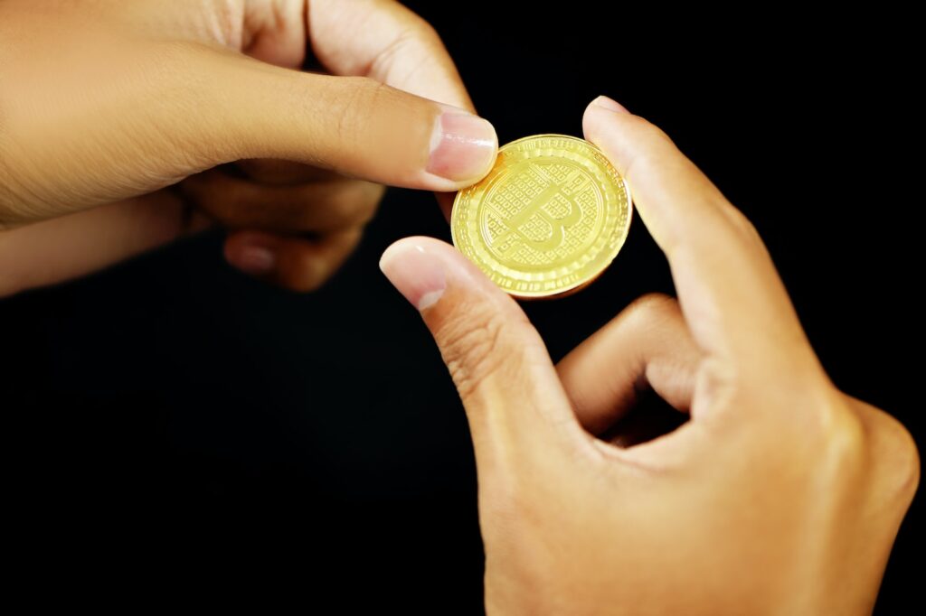 gold round coin on persons hand