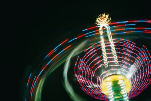 A ferris wheel spinning at night with a blurry background