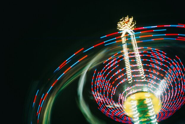 A ferris wheel spinning at night with a blurry background
