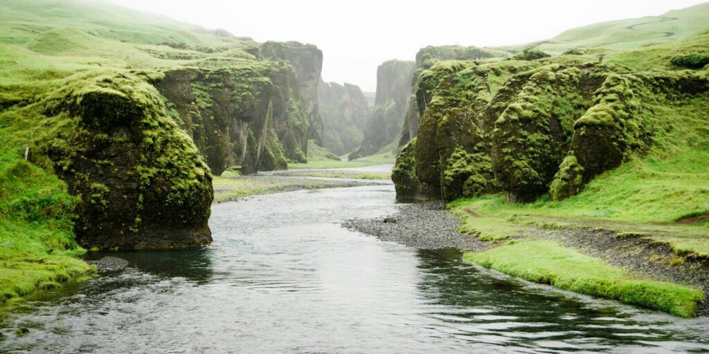 landscape photography of river between green mountains